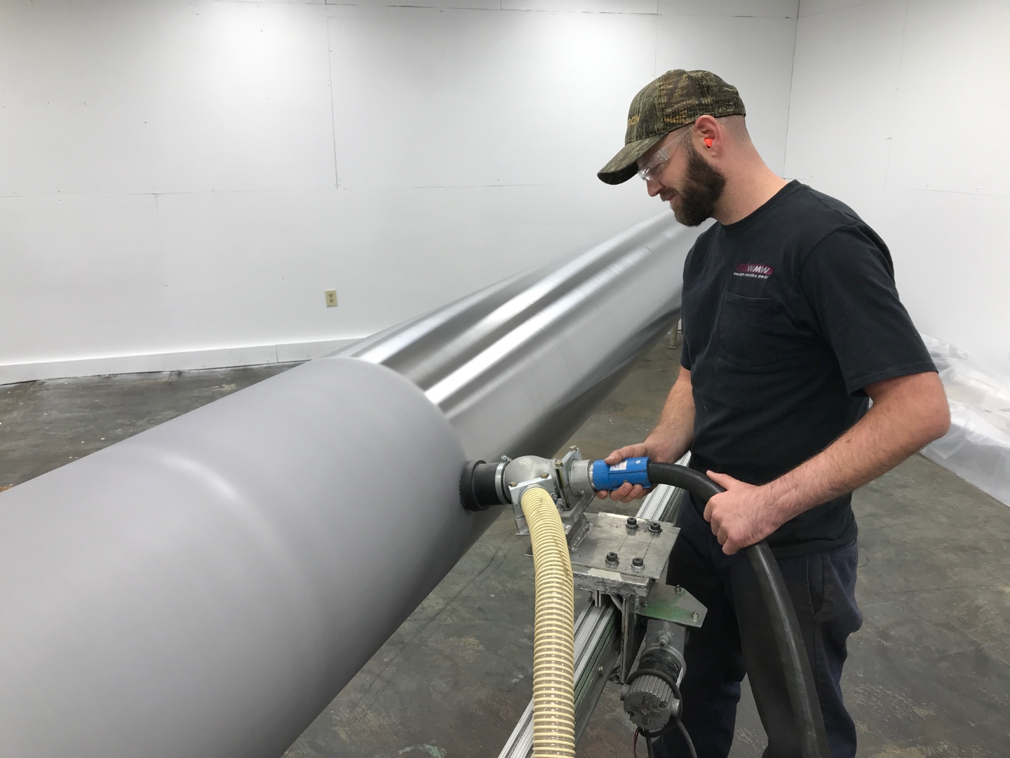 AEGIS technician applying coating to industrial equipment.